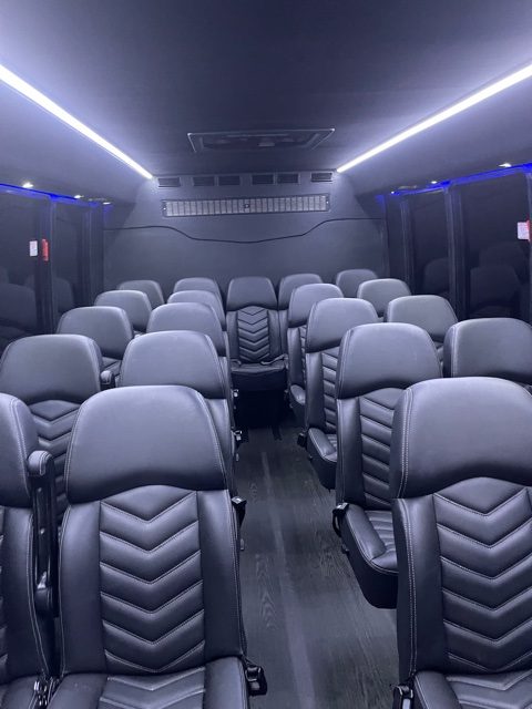 Black interior of a luxury mini coach bus rental with blue and neon lighting inside from Nationwide Bus Charter.